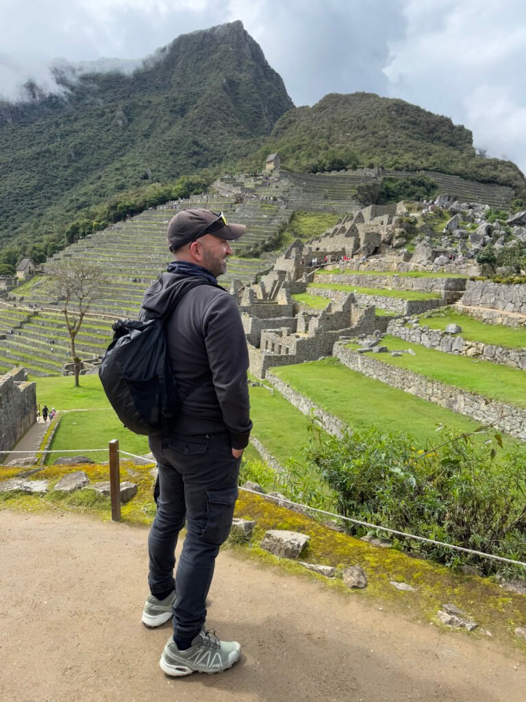 David Berruezo con mochila contemplando las ruinas y terrazas de Machu Picchu desde un mirador.